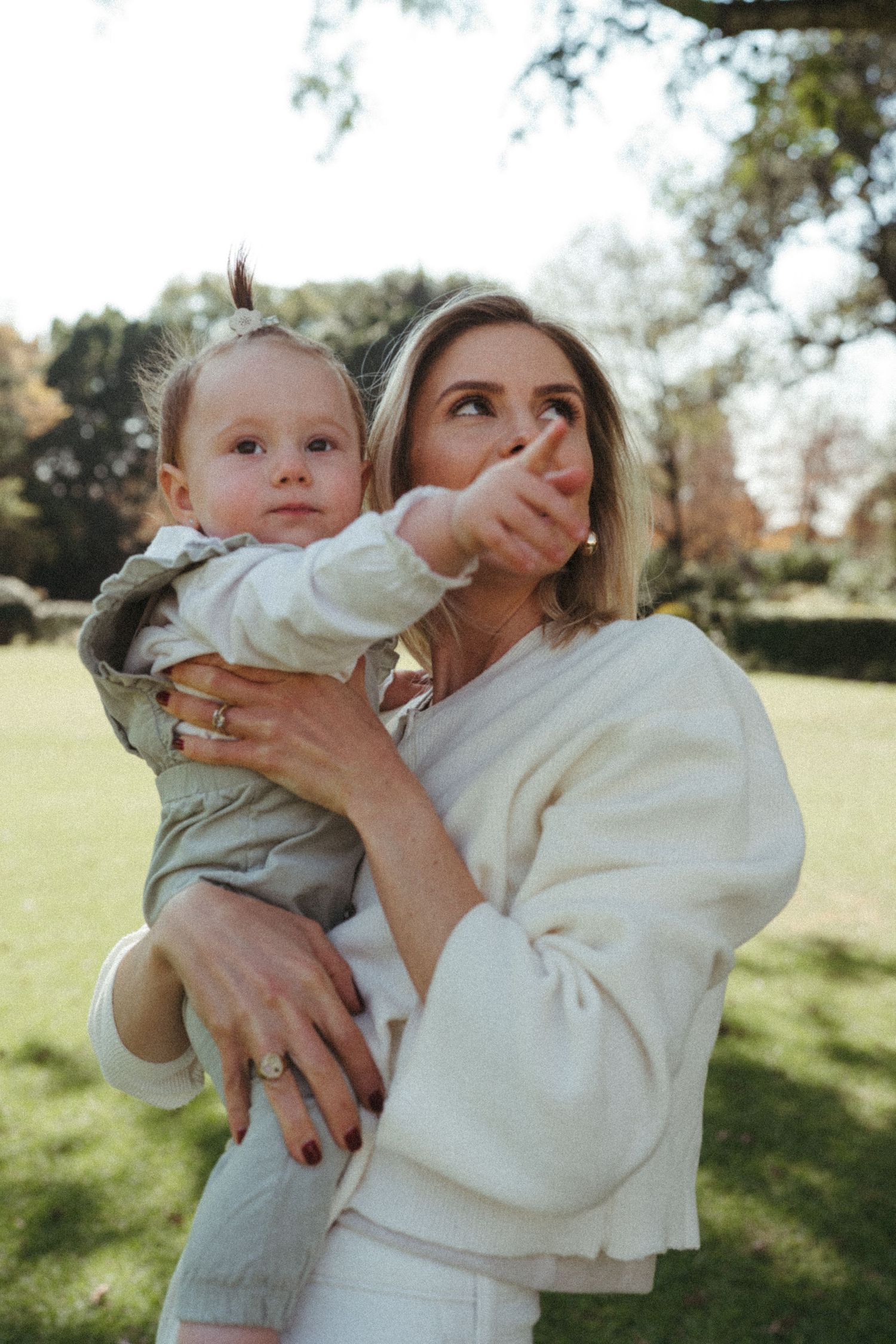 An intimate family moment captured in soft natural lighting at a park.