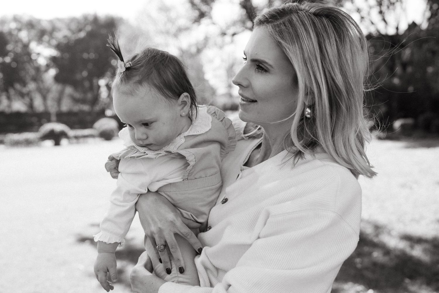 A tender black and white family portrait moment captured outdoors.
