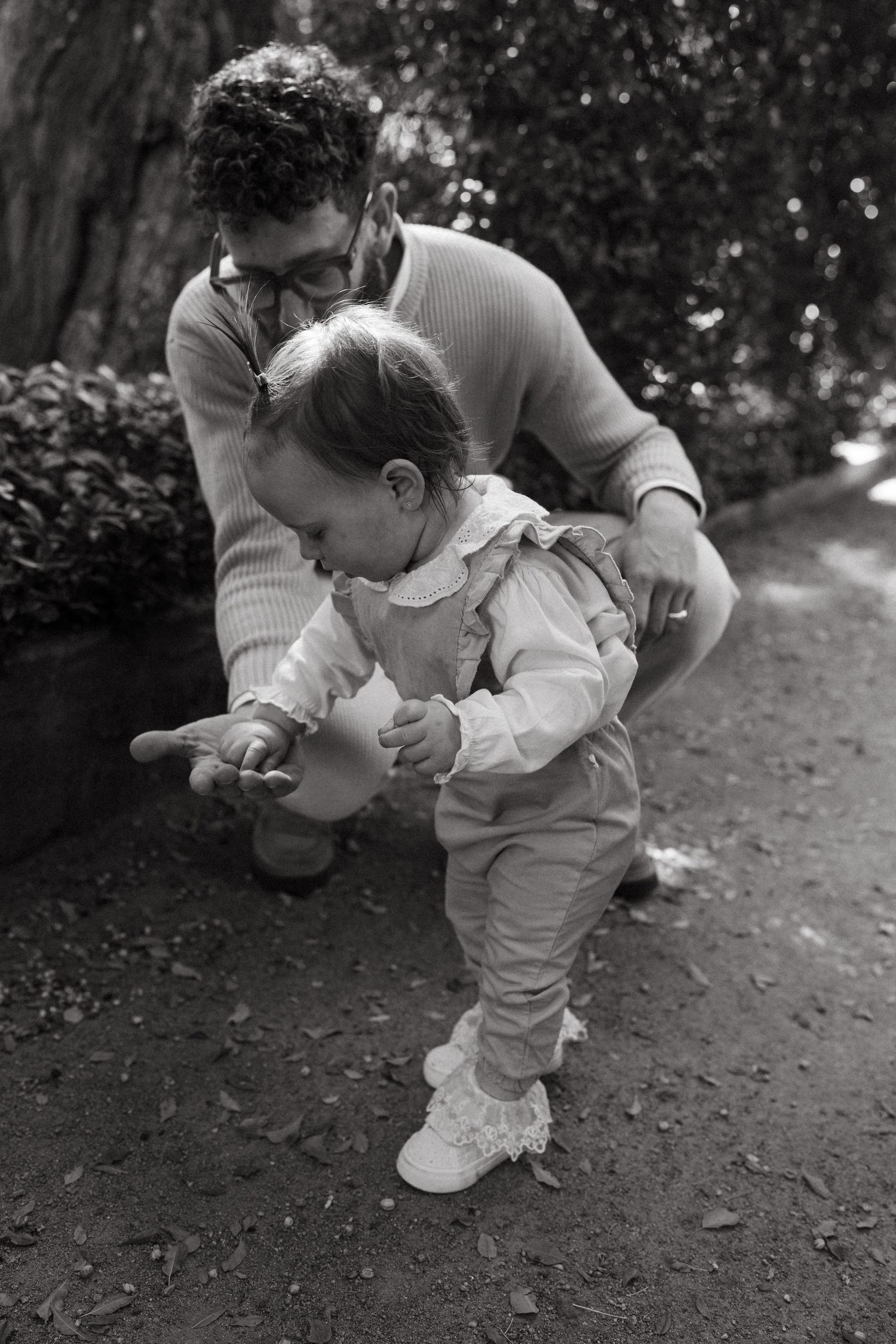 Black and white close-up of a sweet parent-child interaction outdoors.