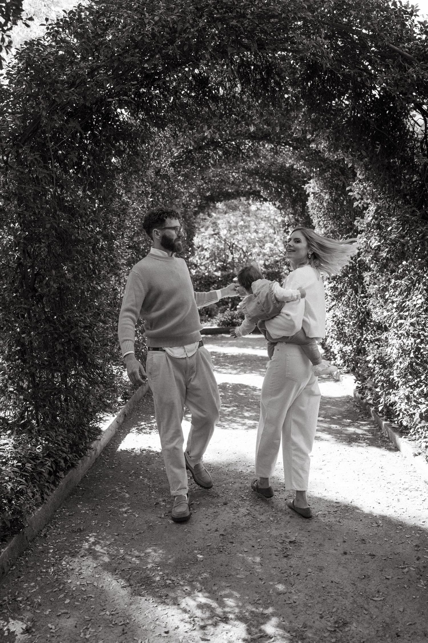 Family enjoying a casual walk through a wooded garden area.