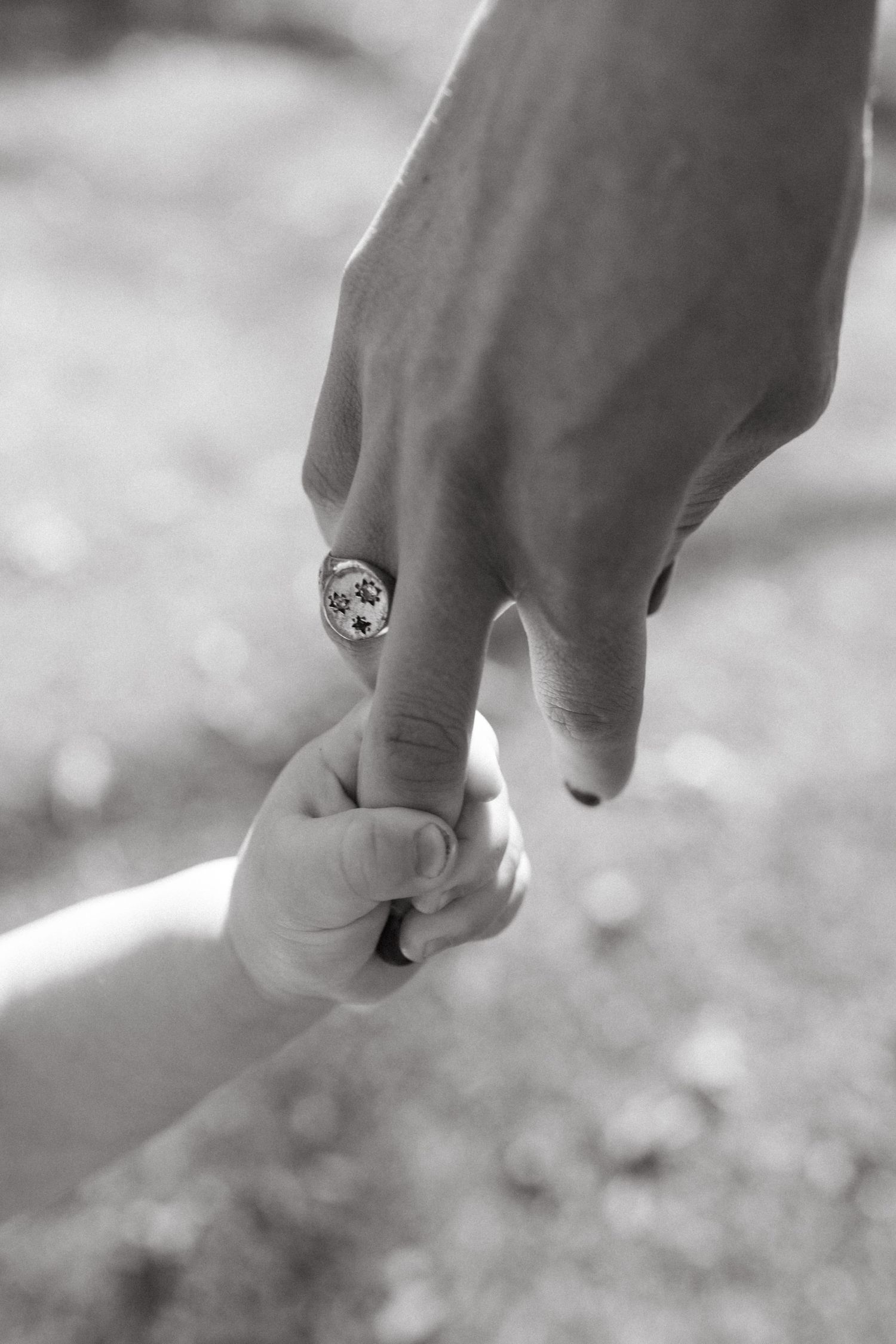 Close-up sequence of hands with an engagement ring in black and white photography.