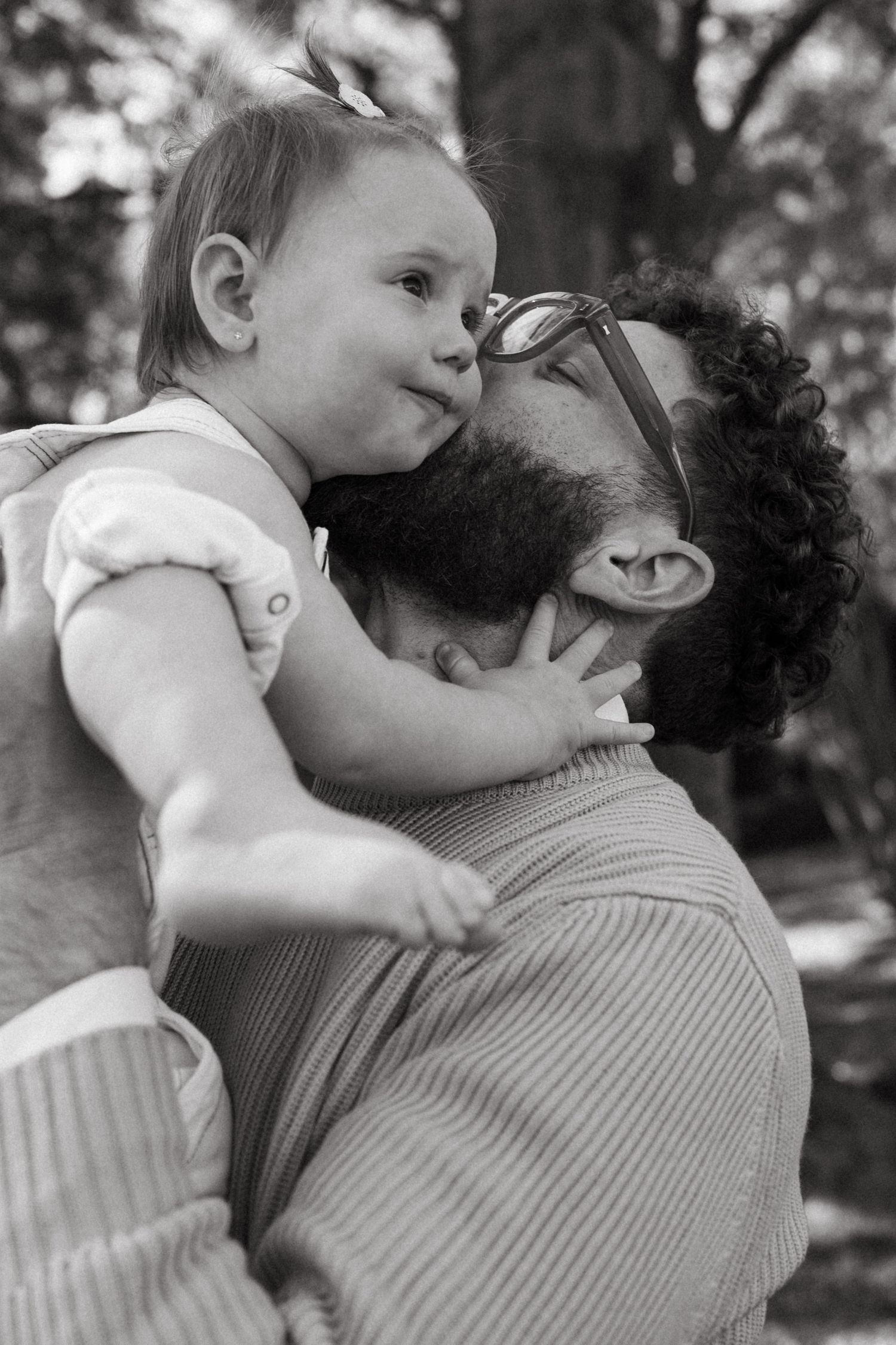 Intimate black and white portraits of parent and child bonding outdoors.