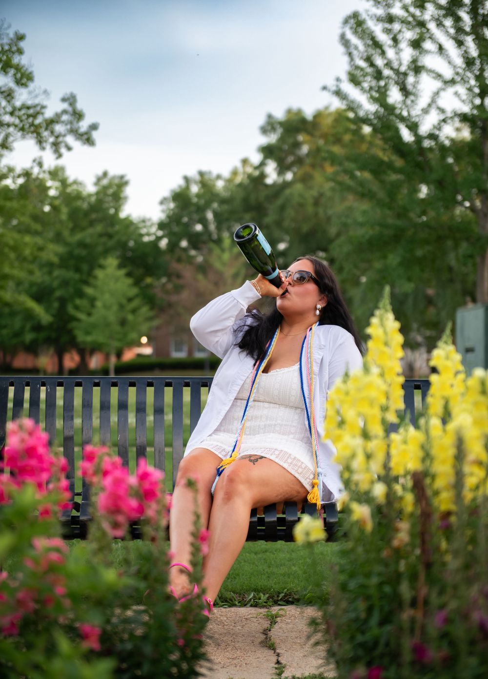 Girl on park bench celebrating graduation