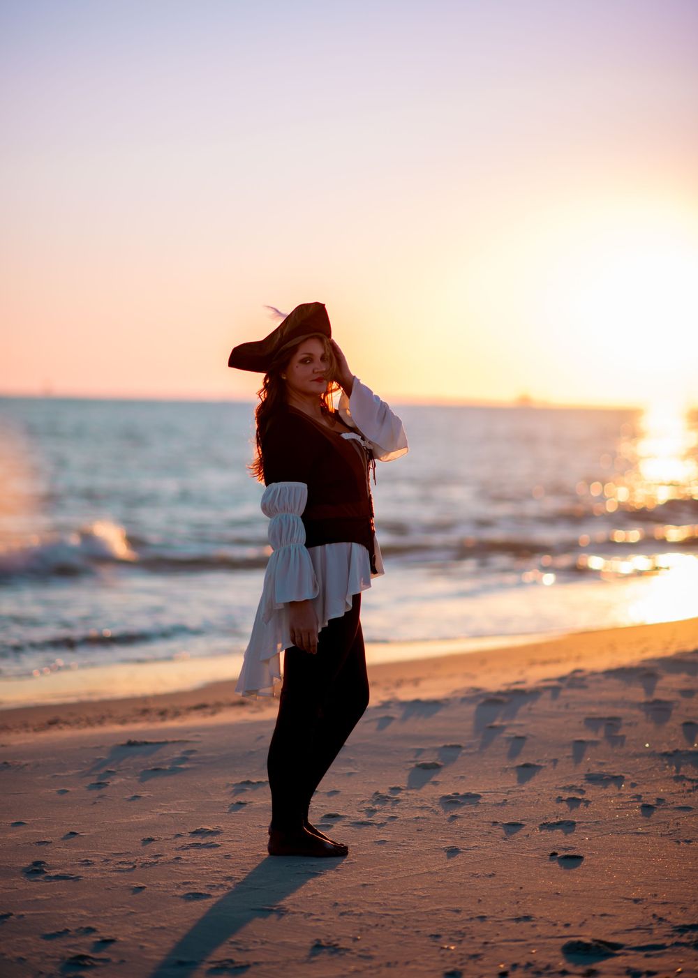 Girl posing as a pirate in sunset