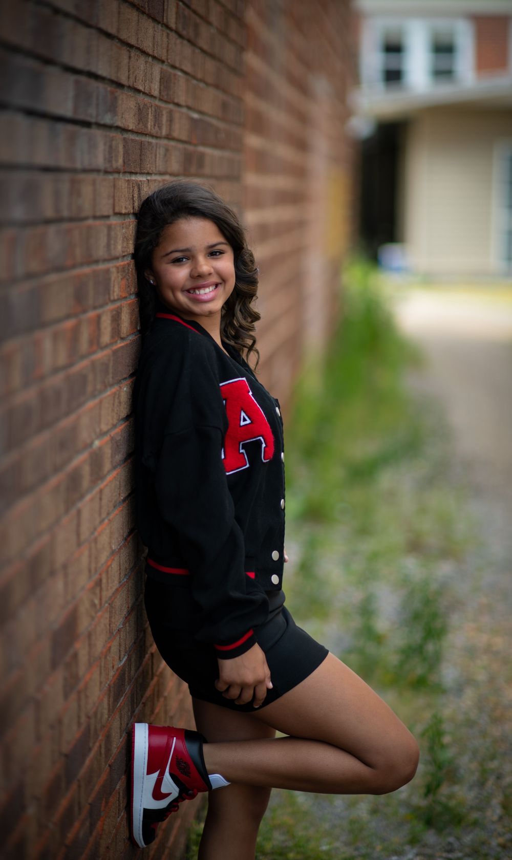 Girl posing for photo against brick wall