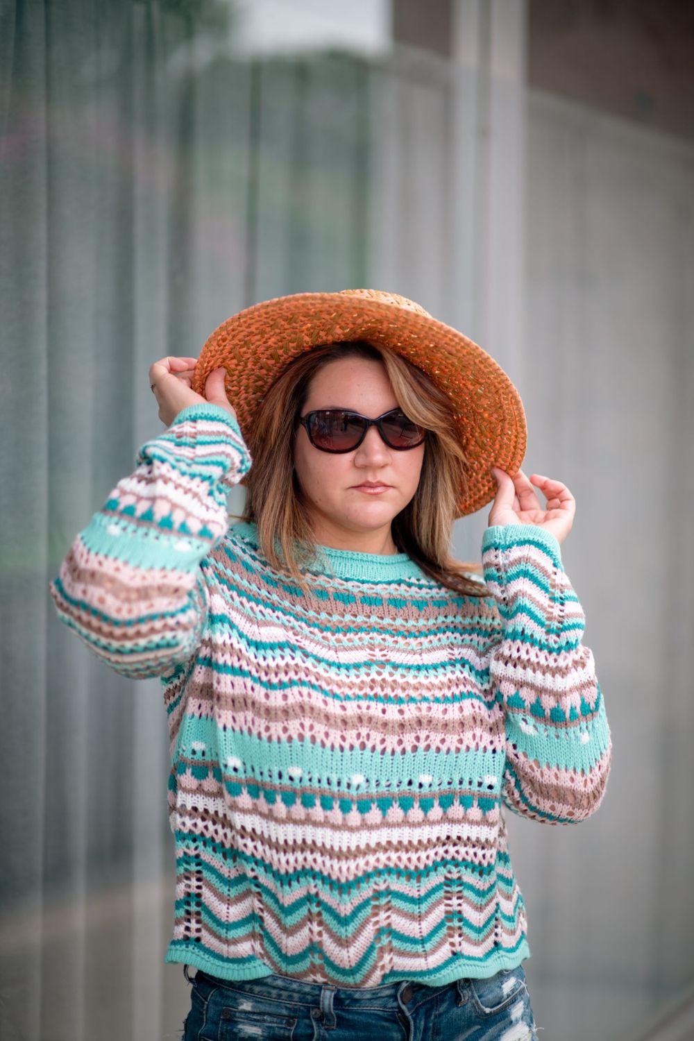 Woman striking a pose in sunglasses and hat