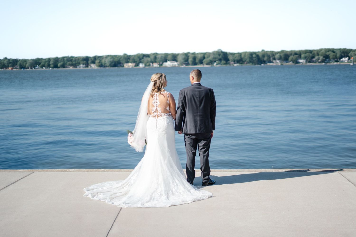 A couple on their wedding day, holding hands.