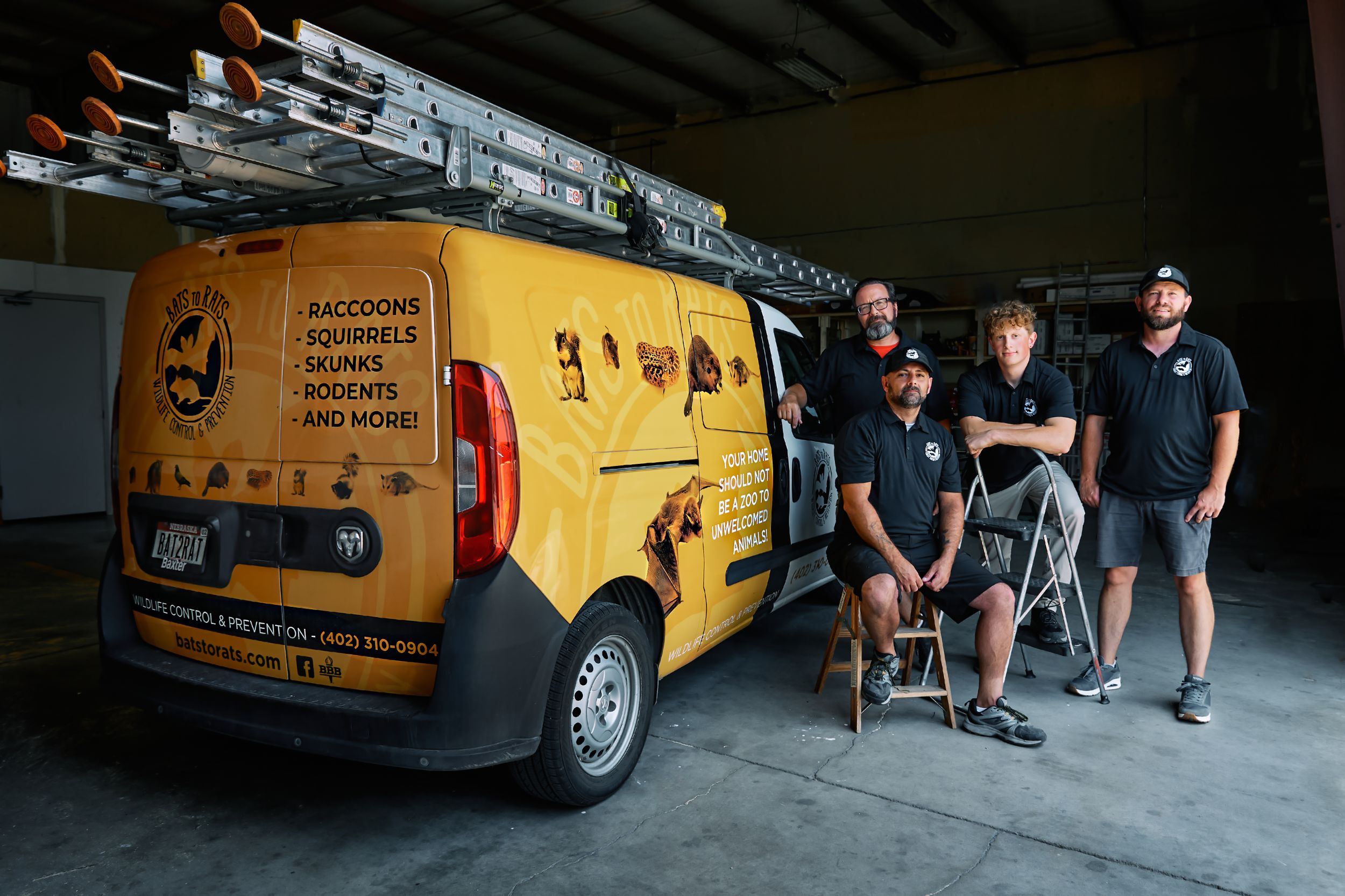 Yellow vintage van parked in shadowy garage space with group nearby.