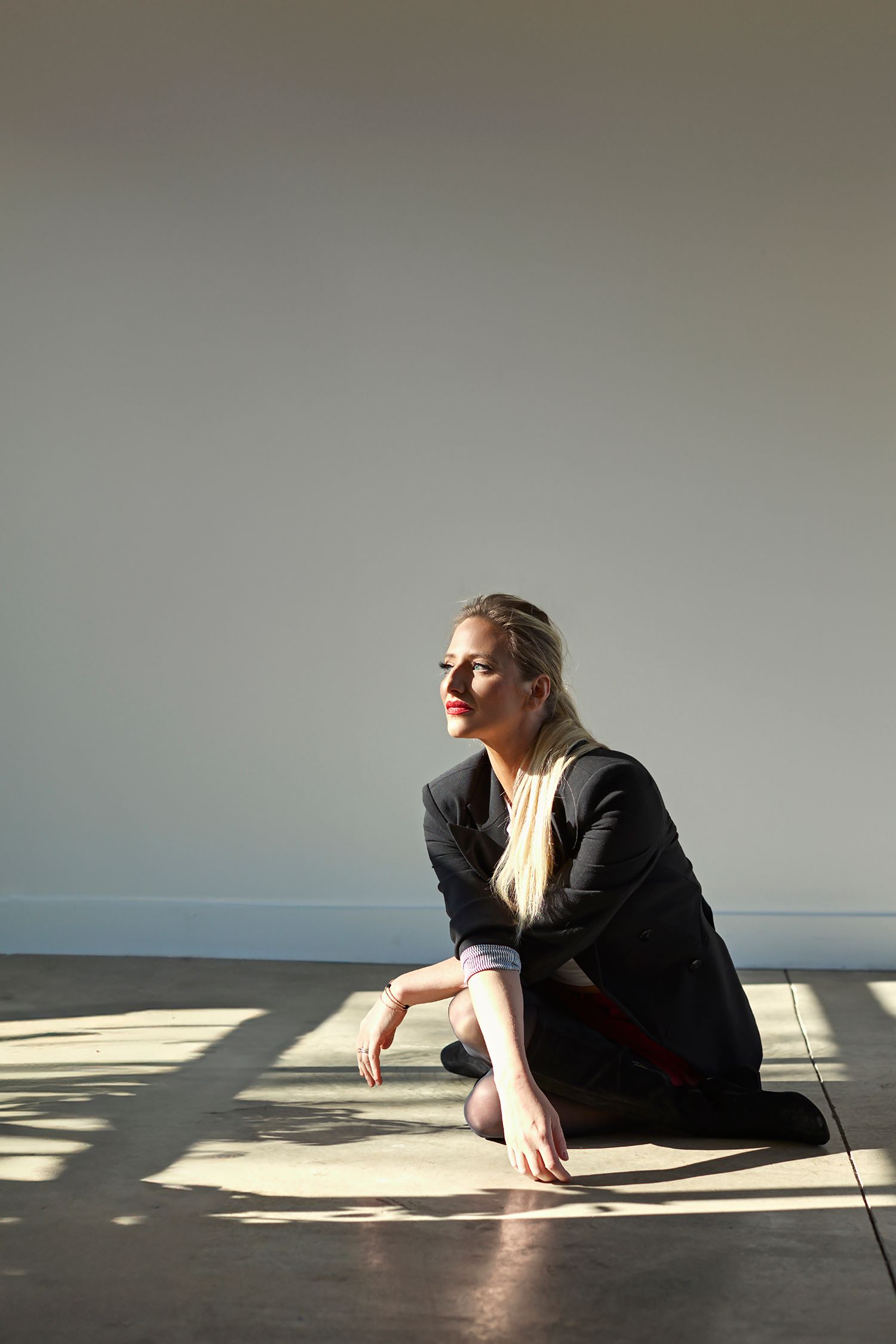 Artistic sequence of person lying in sunlight and shadows on bare floor.