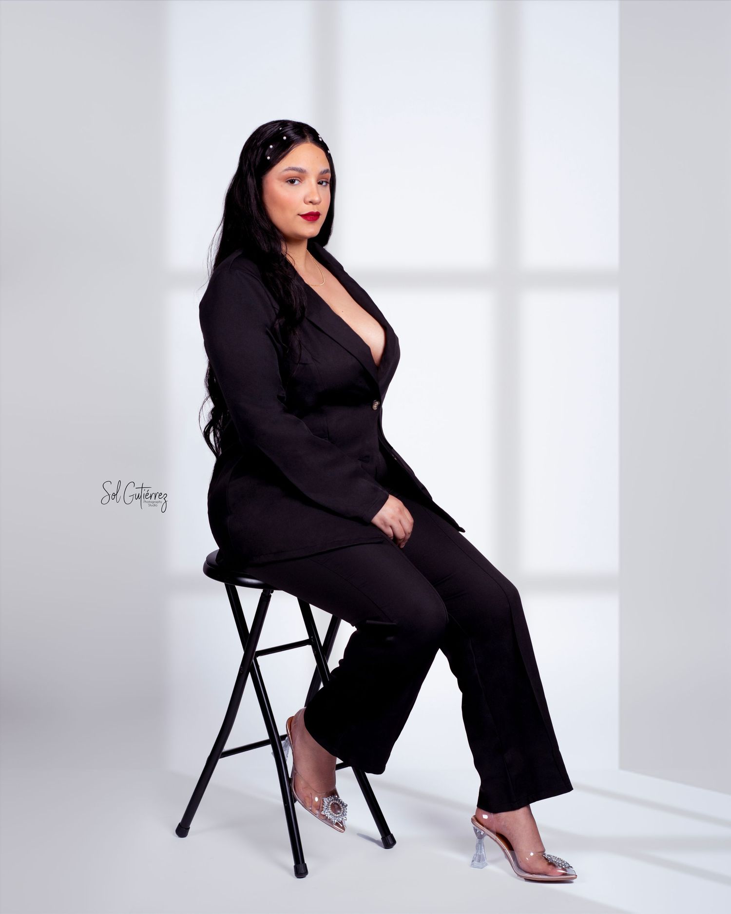 Professional studio photography in Allentown PA featuring woman in elegant black suit sitting on stool