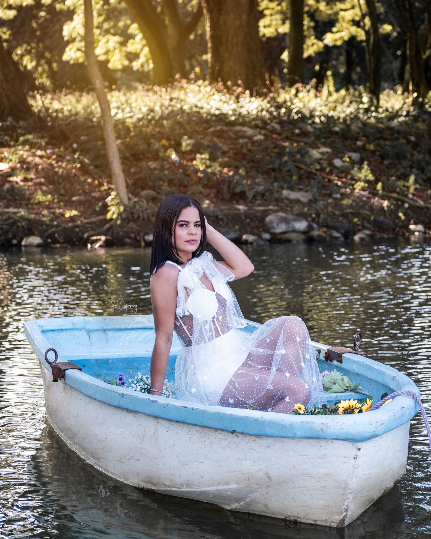 Outdoor portrait photography in Allentown PA of woman in white dress sitting in boat on lake with natural light.