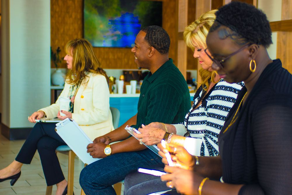 Diverse group of professionals taking notes during a business meeting or training session at a conference room.