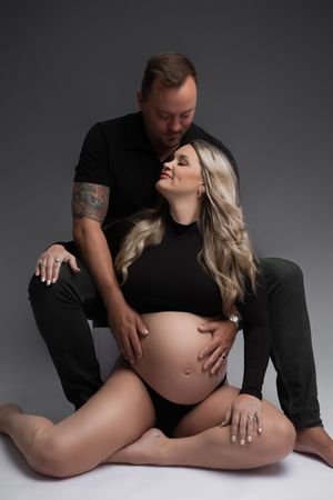 Four artistic maternity photographs show an intimate black and white series focused on a bare pregnant belly.