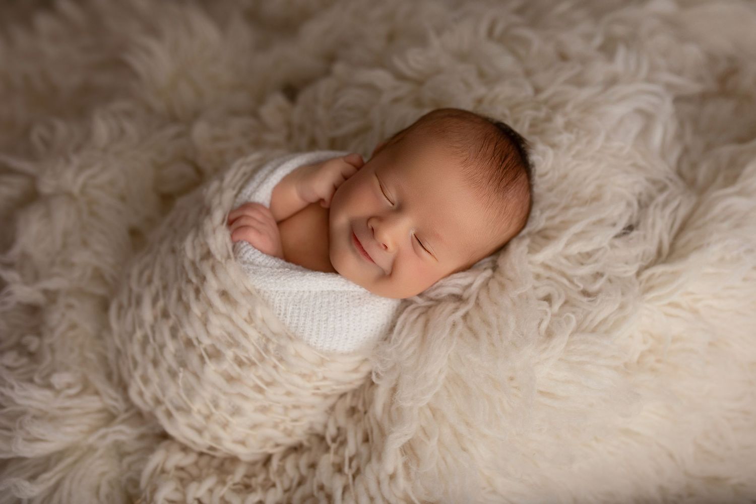 A series of artistic newborn baby portraits on soft white blankets showing peaceful sleeping poses captured from different angles.