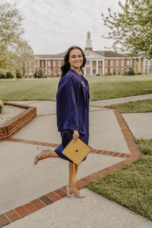 A playful graduation photo showing cap and gown against classic university architecture.