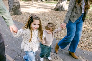 Two children holding hands with their parents