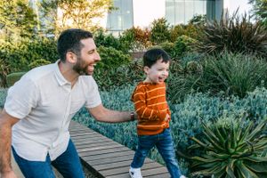 A father and son running alongside succulents in Southern California