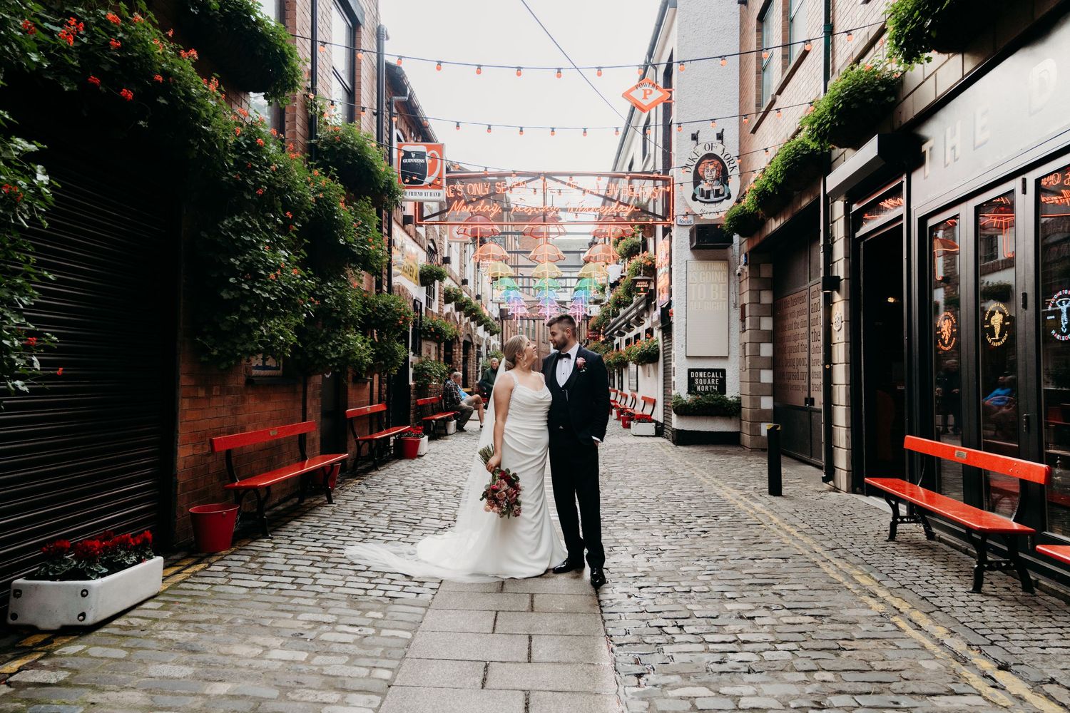 Bride and Groom embracing each other and windswept on their wedding day on the North Coast of Ireland