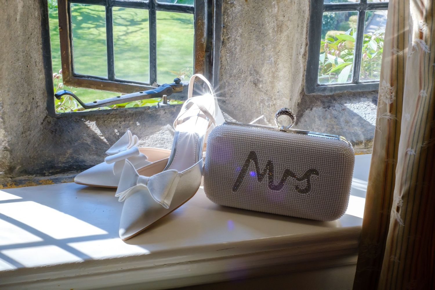 Bridal shoes and gorgeous jewelled handbag on the stone mullion window sill at Holdsworth House in Halifax