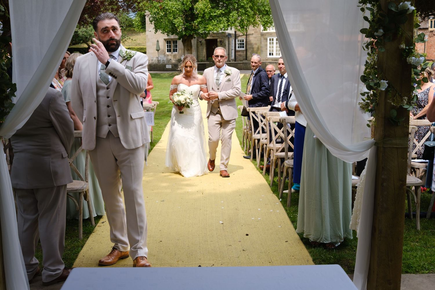 Bride coming down the aisle with her dad. Groom waiting at the front for her. Wedding at The Old Vicarage, Elkesley