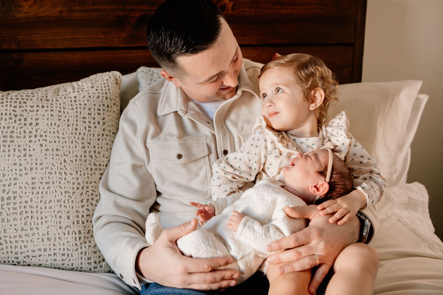 A relaxed family moment on a couch as they spend time together with their newborn baby.