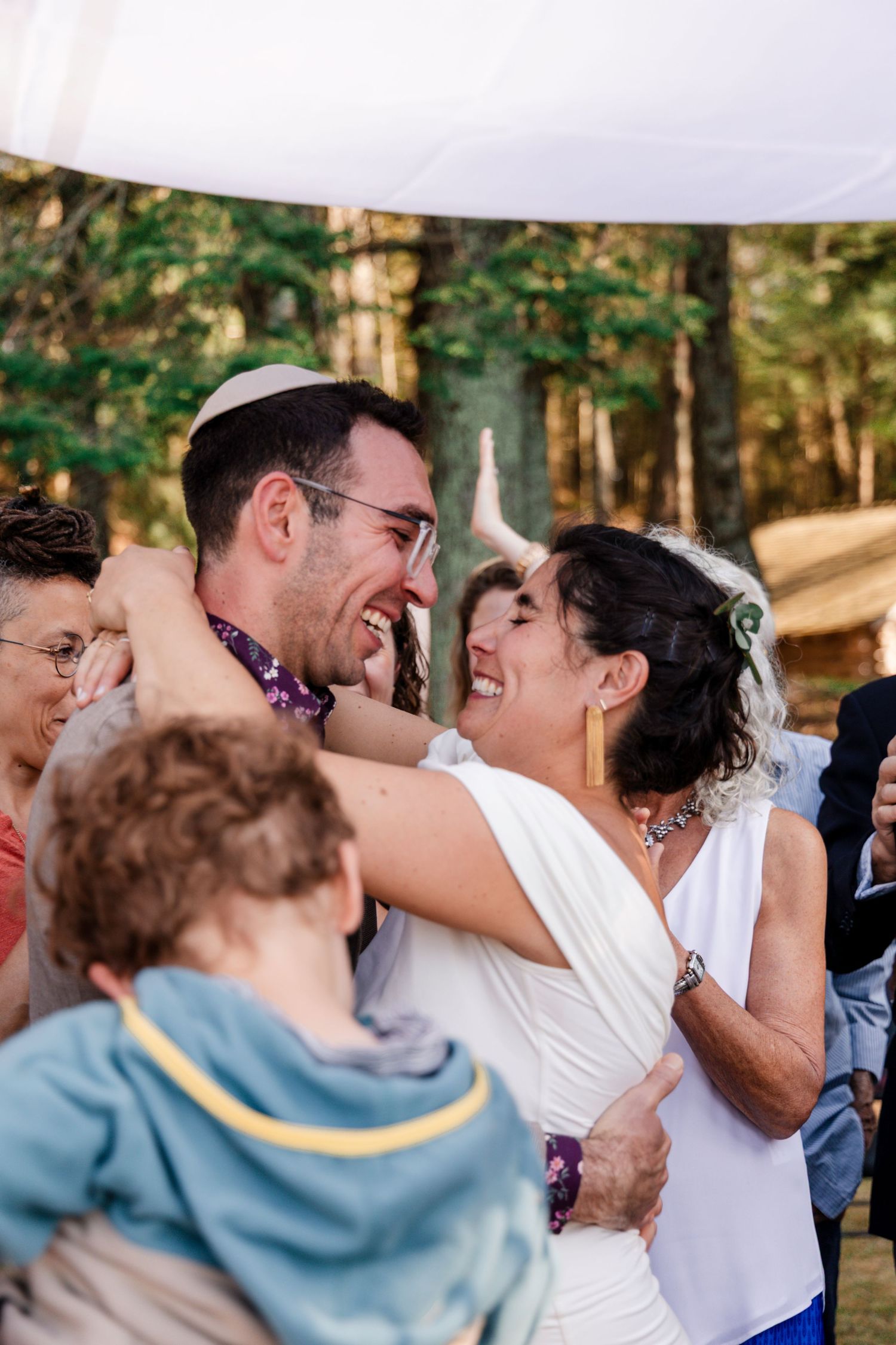 Wedding celebration with dancing couple and burgundy-dressed wedding party.