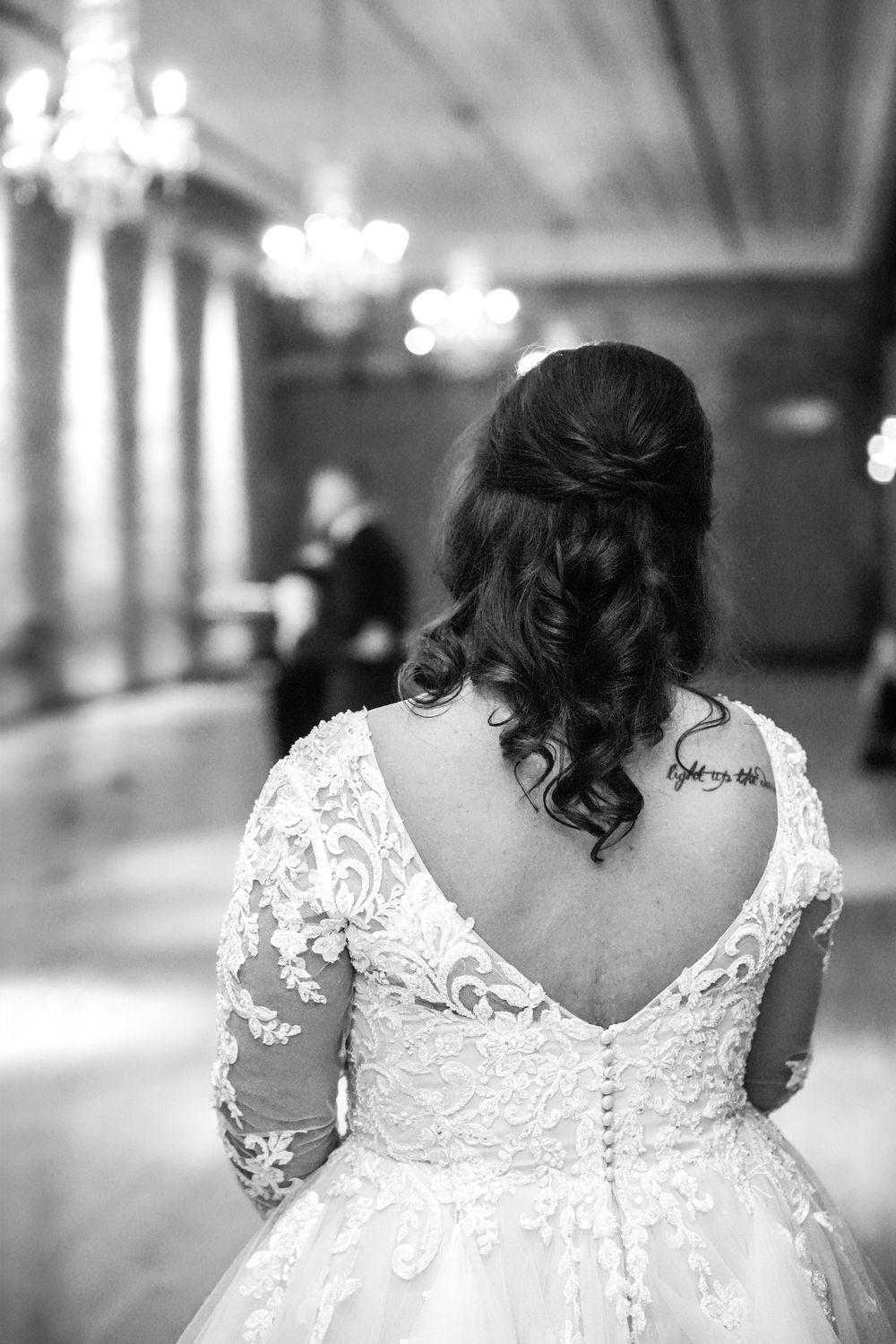 Back view of an intricate lace wedding dress with corset details and delicate embroidery.