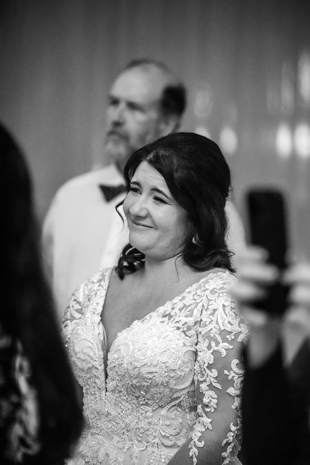 A sequence of black and white portraits showing joyful expressions in an elegant lace dress.