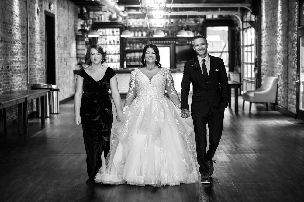 Elegant black and white wedding photo collage showing couples walking through an industrial brick venue hallway.