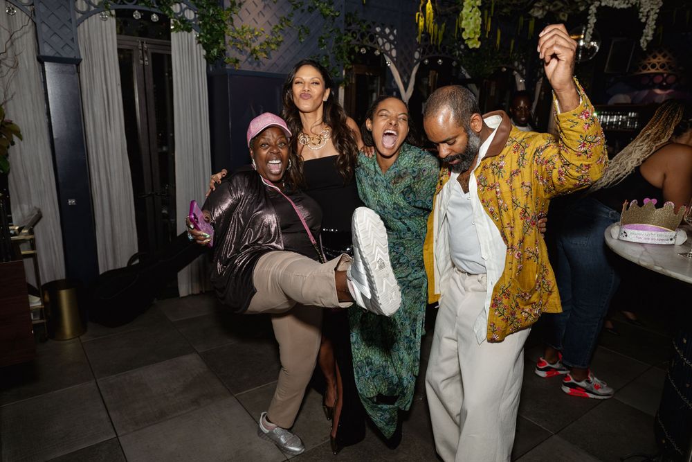 Group of friends having fun and striking energetic poses at a nighttime party celebration.