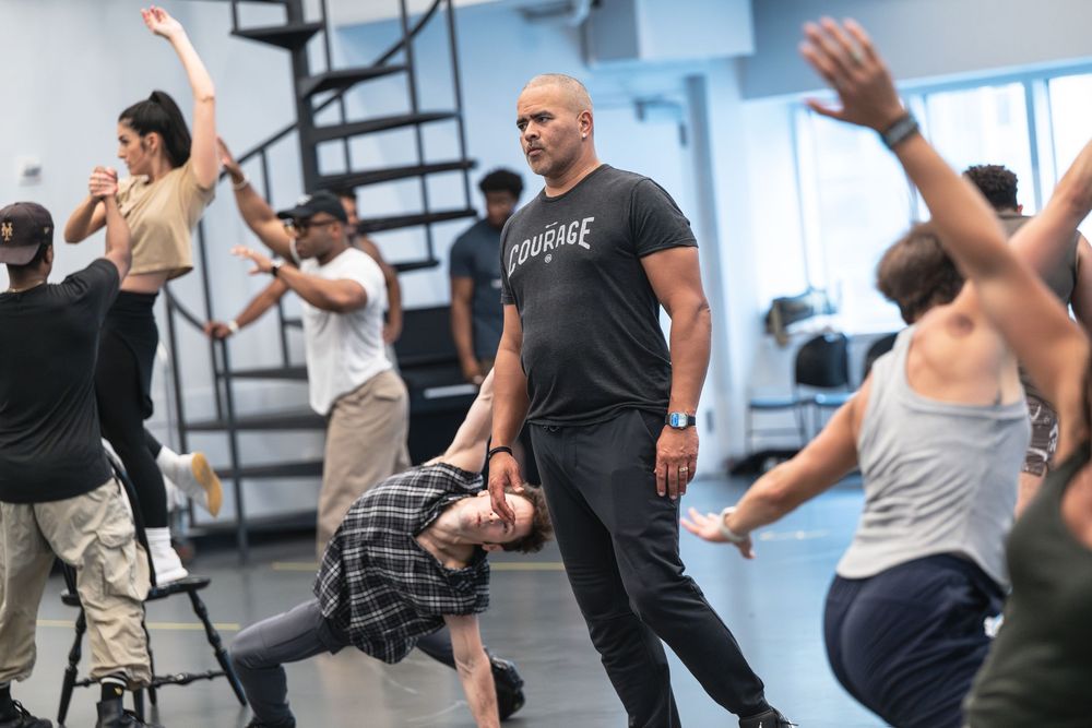 A group of performers dancing and rehearsing in a dance studio during a high-energy class session.