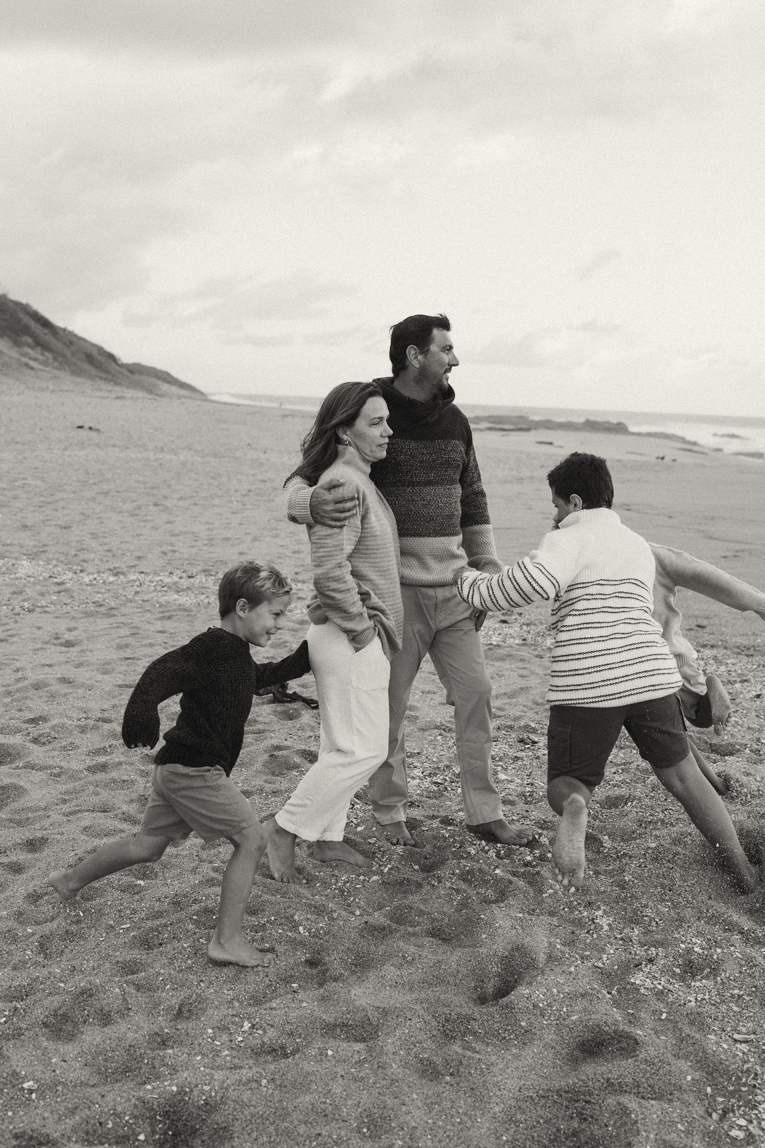 Group enjoying playful moments together on a sandy beach.