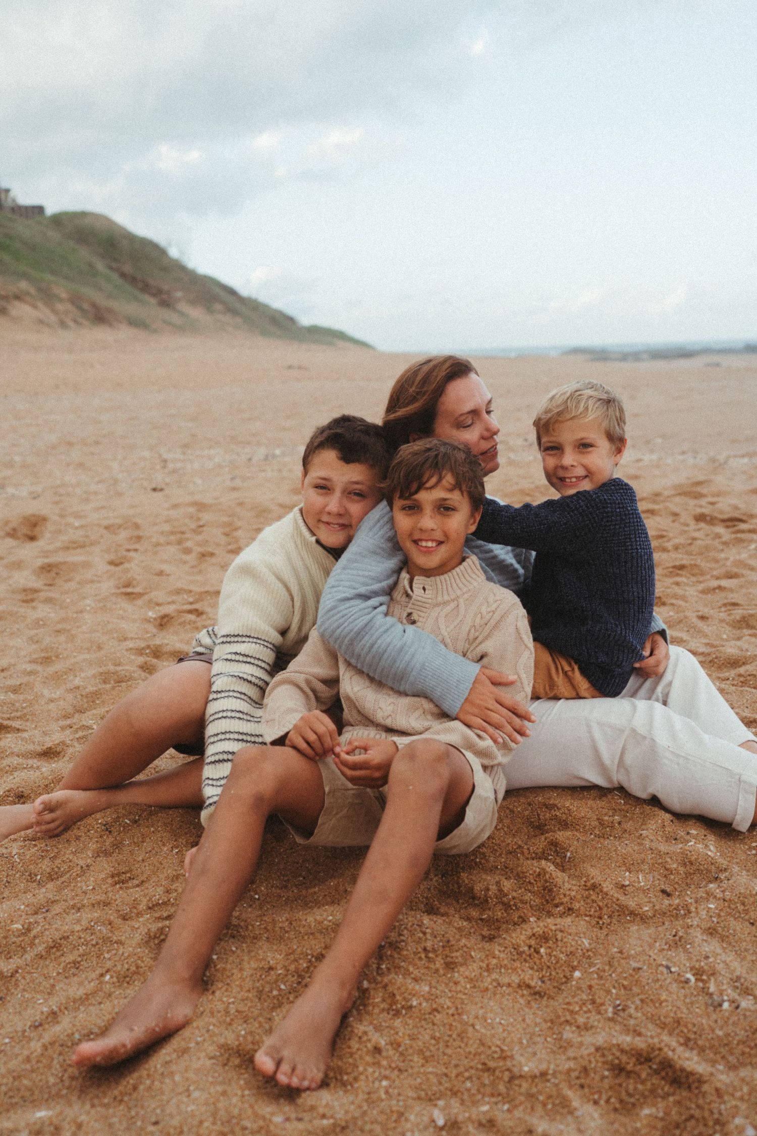 A candid moment of people relaxing together on golden sand at the beach.