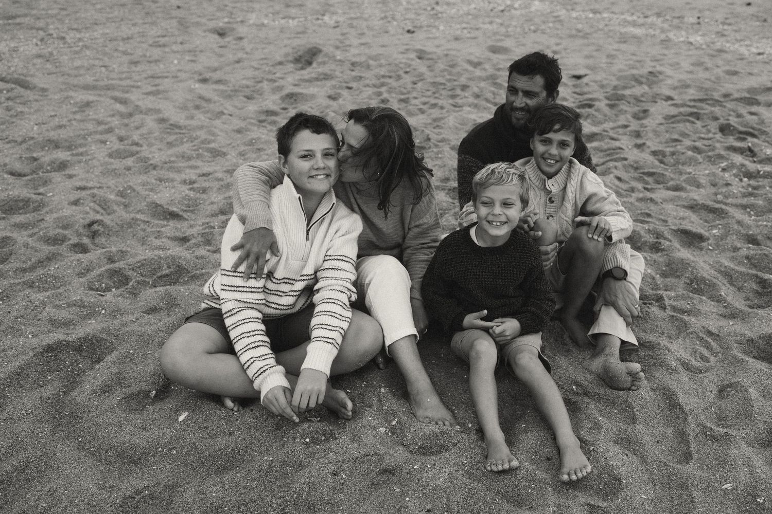 Friends relaxing together on the beach sand.