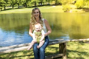 Summer lakeside portrait session with golden sunlight filtering through trees.