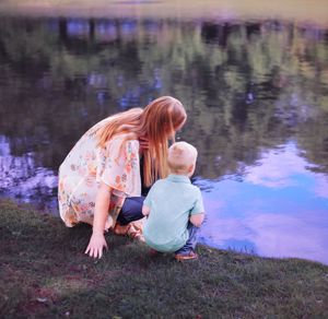 Family enjoying outdoor playtime near tranquil water.