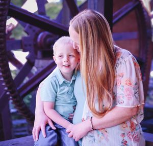 Family members share intimate moment during lakeside photoshoot.