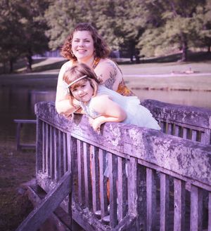 Artistic portrait series on a wooden bridge overlooking a serene lake.