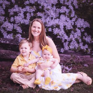 Colorful spring portrait session under blooming purple cherry blossoms in a park setting.
