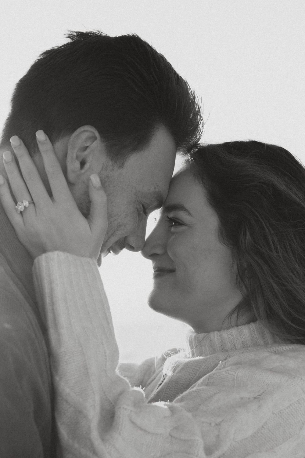A tender romantic moment captured in black and white as a couple shares an intimate embrace.