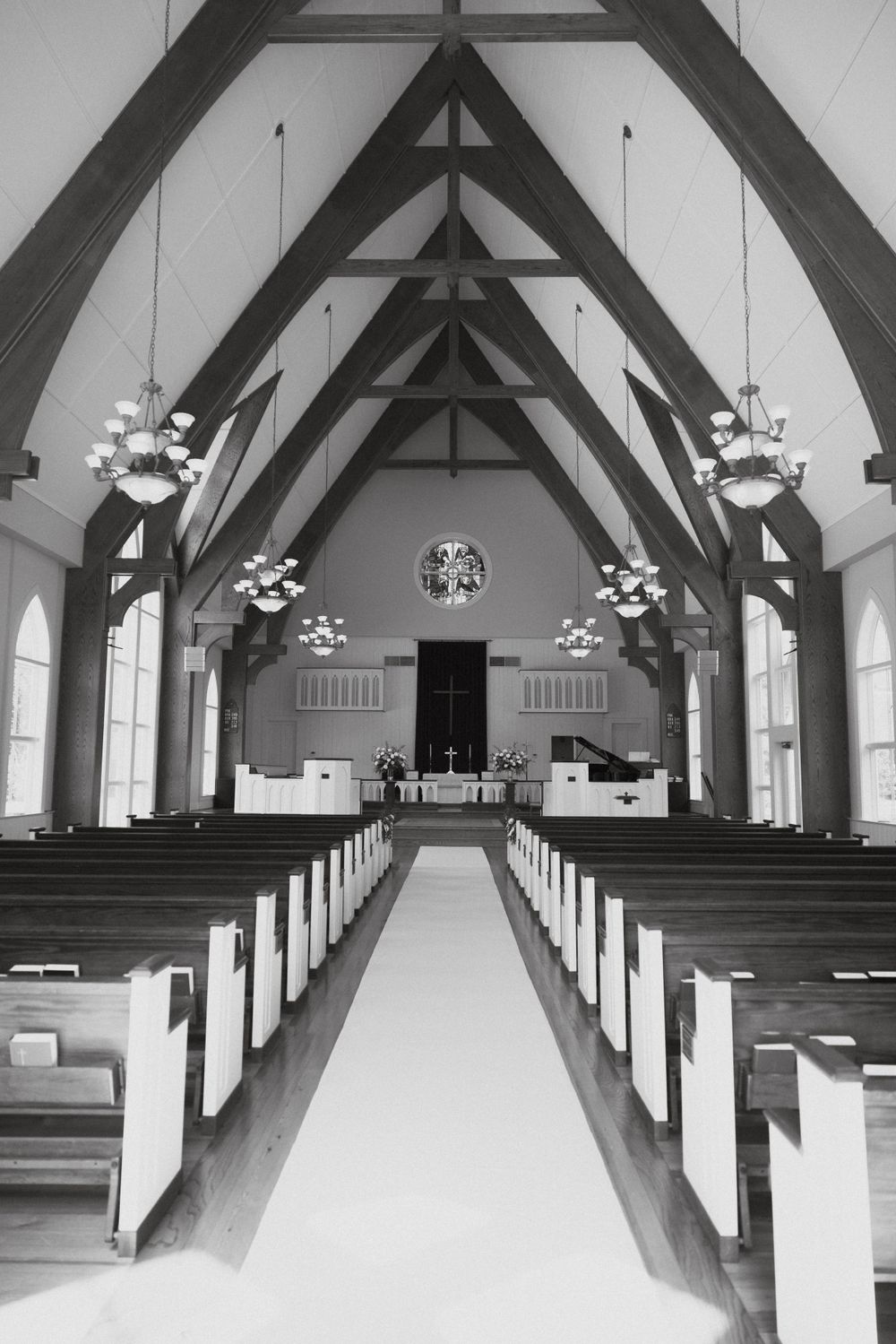 Black and white interior of church with dramatic vaulted ceiling and center aisle.