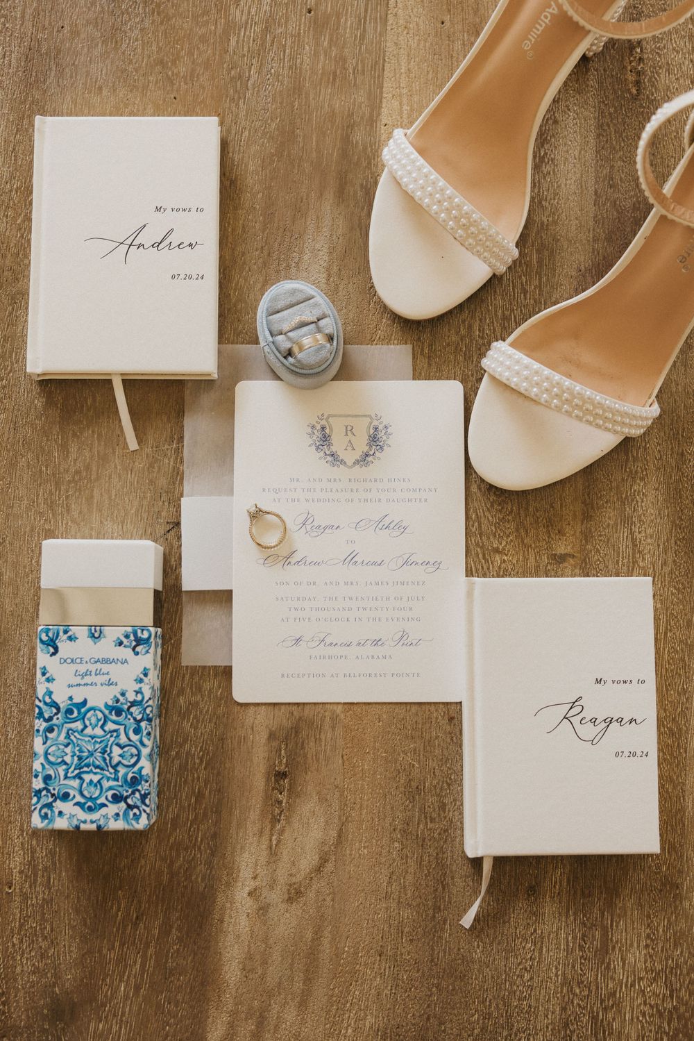 Wedding invitation suite with white heeled sandals and blue accents on wooden surface.