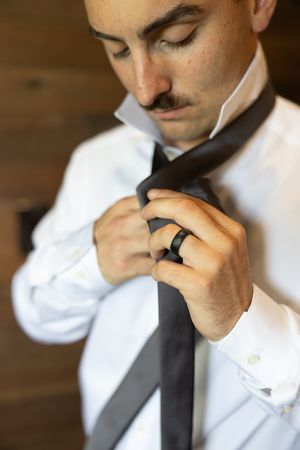 Orlando luxury wedding photographer groom adjusts his black tie