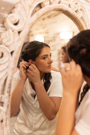 Orlando luxury wedding photographer bride putting on her earrings.