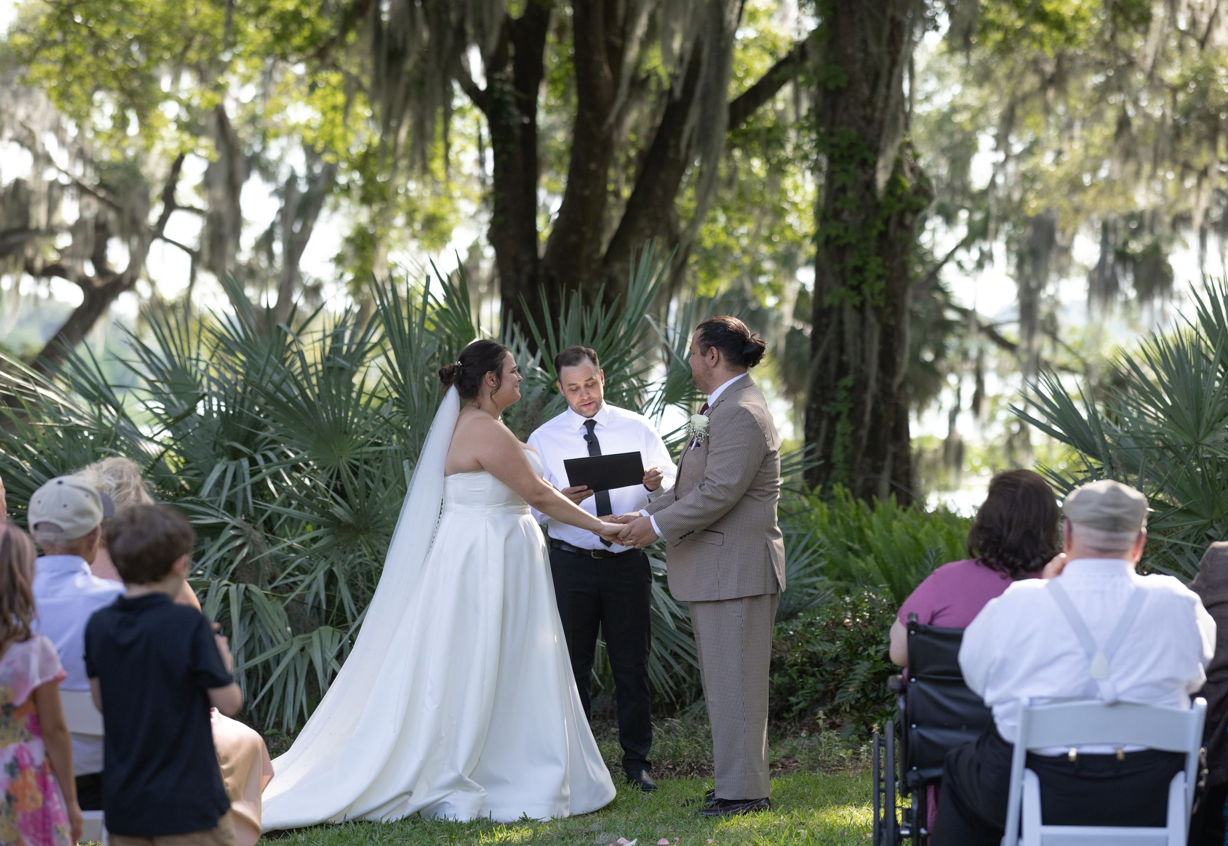Orlando luxury wedding photographer bride and groom under the oak trees during their ceremony.