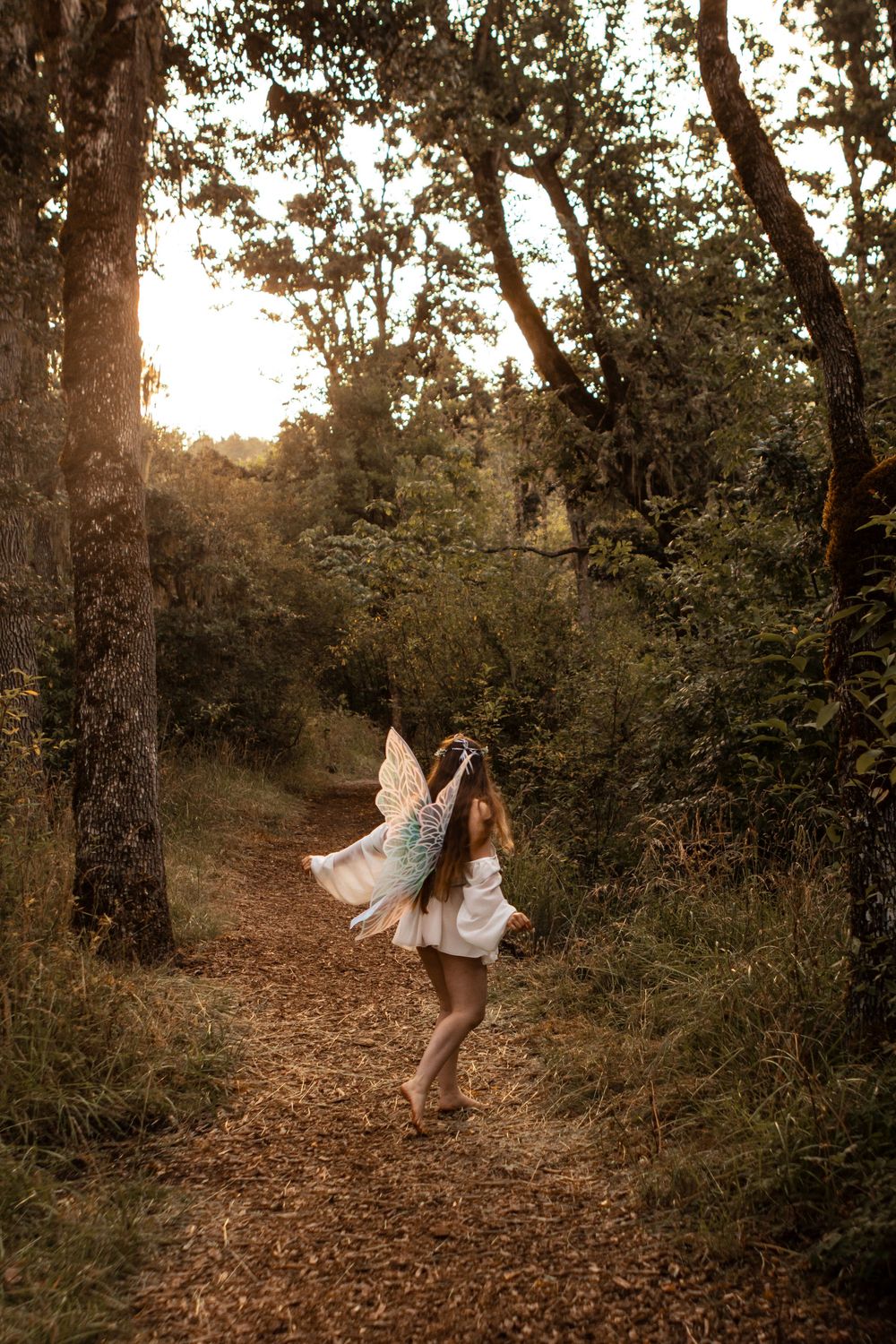 Young model dressed in white as a fairy in the woods near Eugene