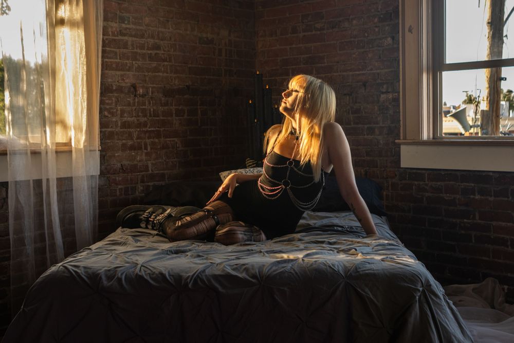 Candice (Bandicex) poses on a bed.  She is glowing in the sun, in Junction City, Oregon.