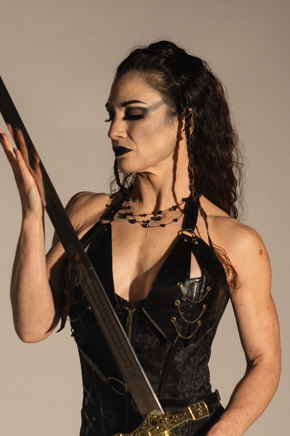 Kristen Barber models in a studio in Junction City, Oregon. There is a white background and she carries a sword.