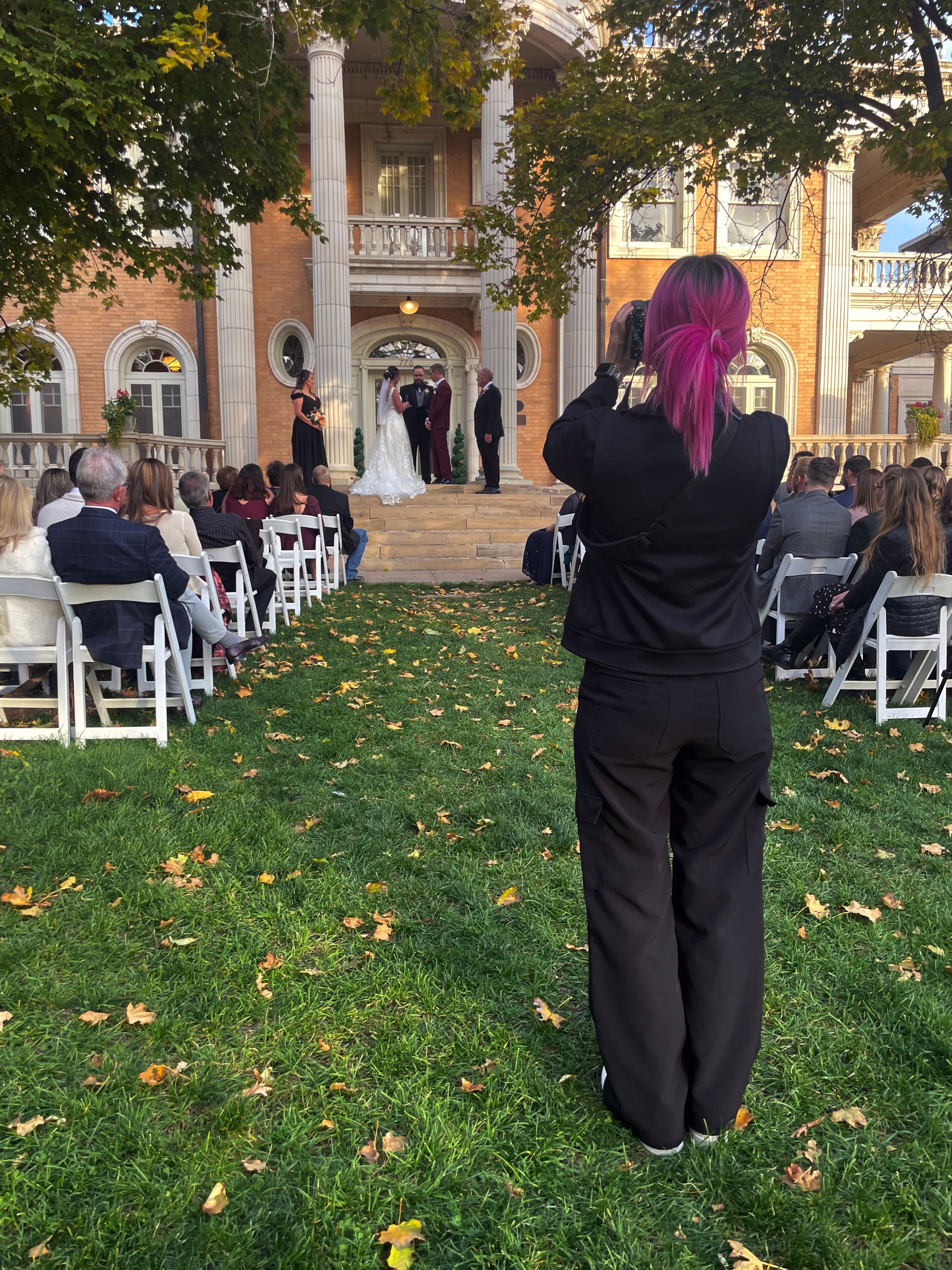 Wedding photographer capturing ceremony at the historic Grant Hu Grant Humphrey's mansion with fall foliage.