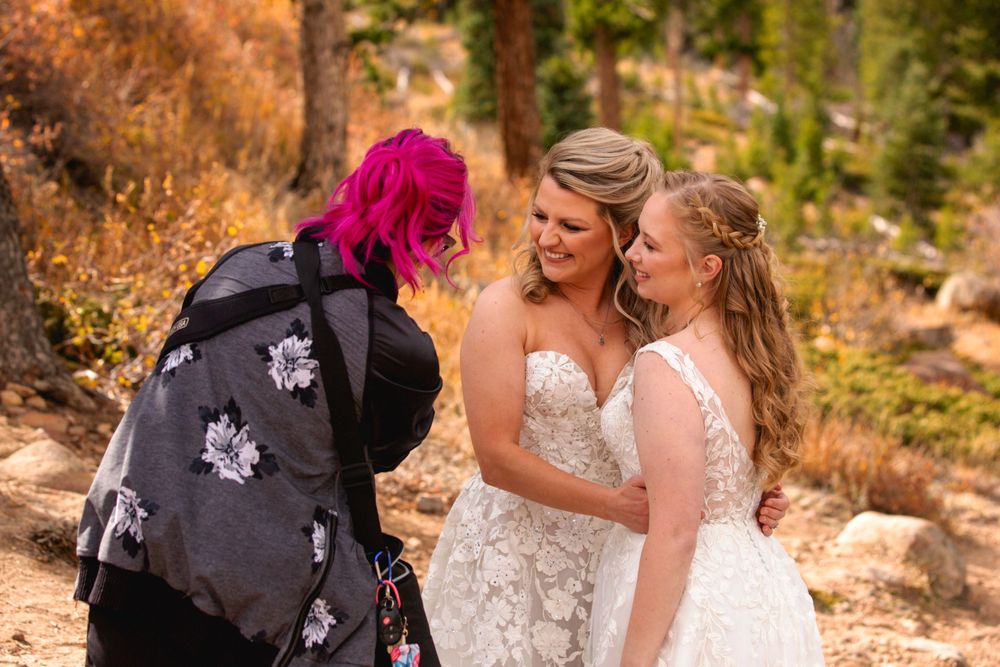 Outdoor mountain LGBTQ+ wedding photoshoot with photographer in vibrant pink hair.